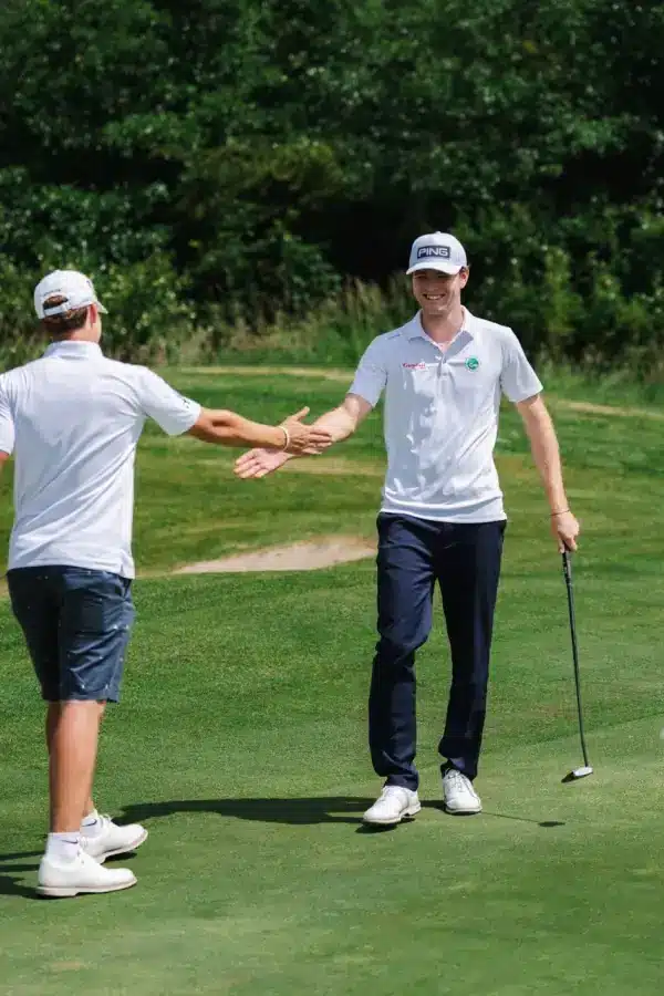 Zwei Spieler des GC Hubbelrath gratulieren sich auf dem Grün während des DGL-Spieltags im Golf Club Hösel.